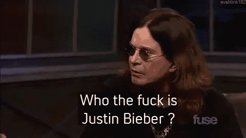 a man wearing sunglasses and a necklace is asking who the fuck is justin bieber