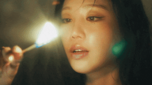 a close up of a woman 's face with a light shining on it