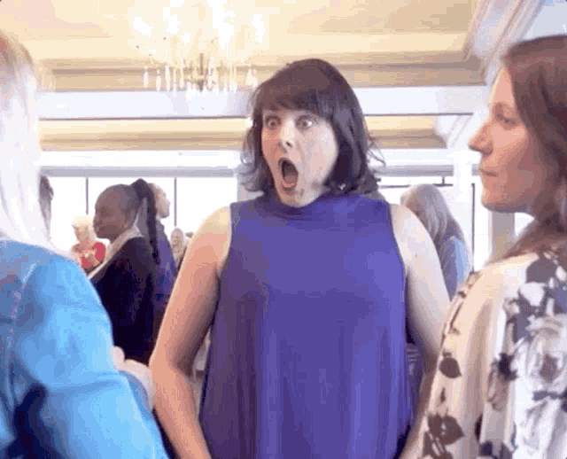 a woman in a blue dress has her mouth wide open