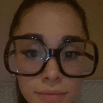 a close up of a woman wearing glasses and making a funny face .