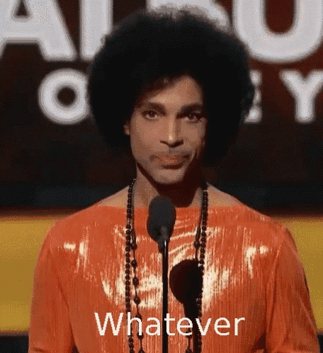 prince is standing in front of a microphone wearing an orange dress and necklace and says whatever .