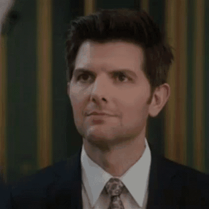a close up of a man in a suit and tie making a funny face .