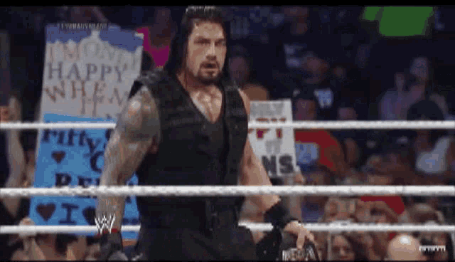 a man in a wrestling ring with a sign that says happy when i 'm ruffy