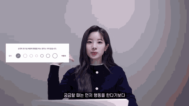 a woman in a blue sweater holds up a sign that says ' circle ' on it