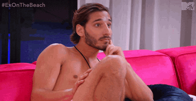 a shirtless man is sitting on a pink couch with the hashtag #exonthe beach