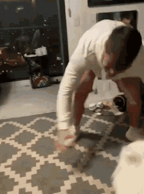 a man is doing a handstand on a rug in a room