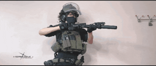 a person in a military uniform holding a rifle with a website written on the bottom