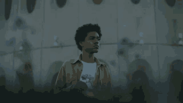 a young man is standing in front of a building and looking at something .