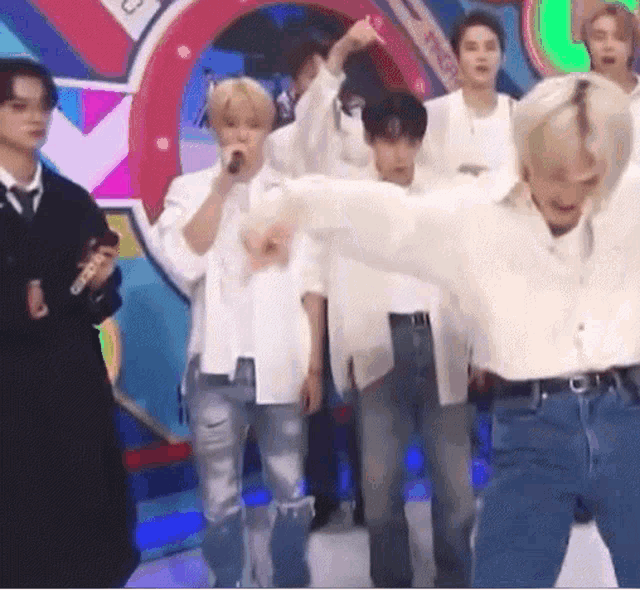 a group of young men are standing on a stage and dancing .