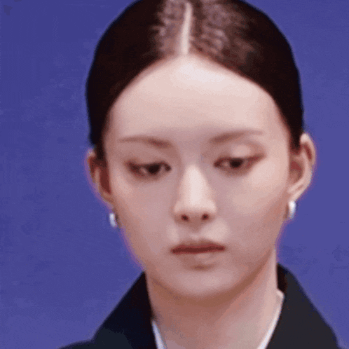 a close up of a woman 's face against a blue background .