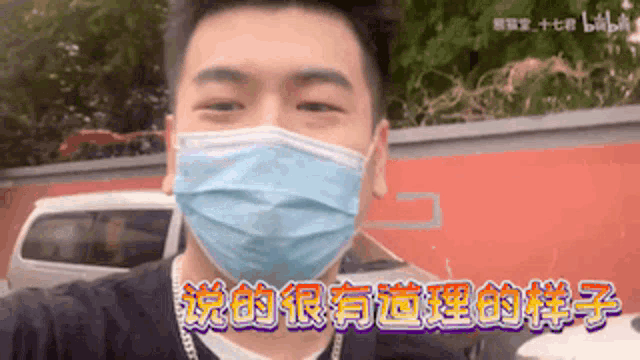 a man wearing a blue face mask with chinese writing on it