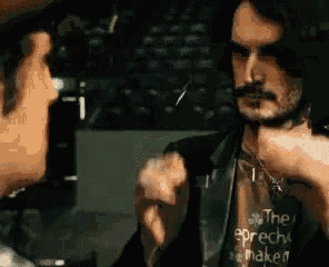 a man with a beard and mustache is wearing a t-shirt that says the speech maker .