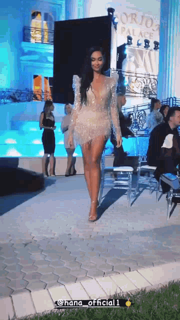 a woman in a short white dress is walking down a runway