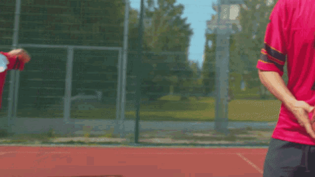 a man in a red shirt holds a spalding basketball in his hand