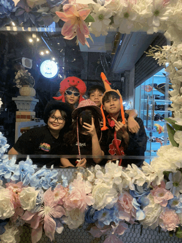 a group of people are posing for a picture in front of a floral frame