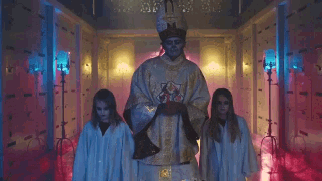 a man with a skull on his face is standing next to two children