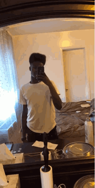 a man taking a picture of himself in a bathroom mirror