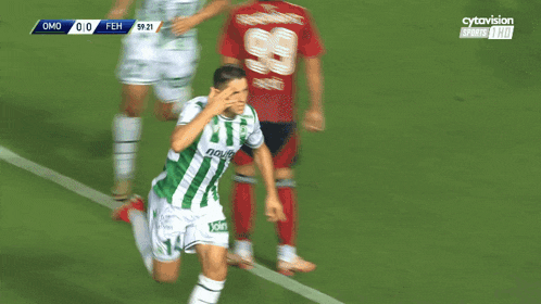 a soccer player in a green jersey with the number 14 on it