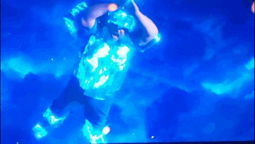 a man is dancing in a dark room with a blue light behind him .