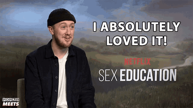 a man is sitting in front of a poster that says " i absolutely loved it "