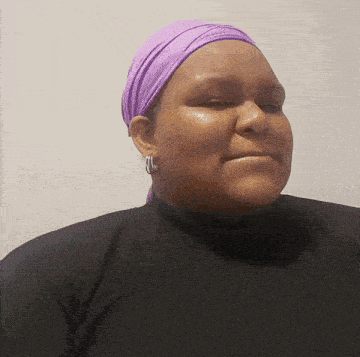 a woman wearing a purple head scarf and earrings