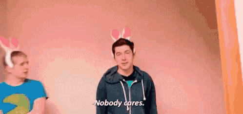 a man with bunny ears on his head is standing next to another man .