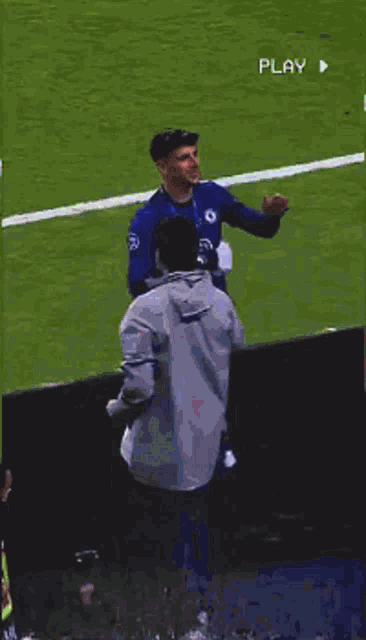 a man wearing a blue shirt with the number 3 on it is standing on a soccer field .