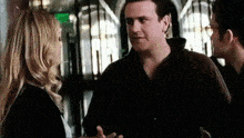 a man and a woman are standing next to each other and talking .