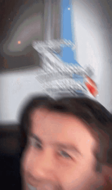 a blurry picture of a man 's face with a bottle of soda on his head