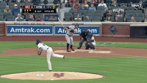 a baseball game is being played in front of an amtrak advertisement