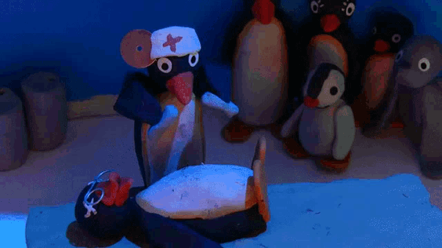 a group of stuffed penguins including one wearing a doctor 's hat and gloves