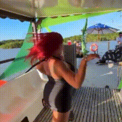 a woman with red hair is standing on a boat holding a surfboard