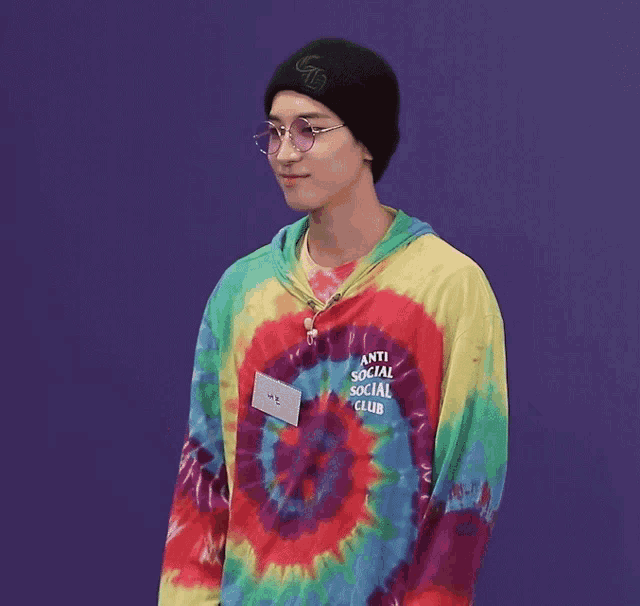 a young man wearing a tie dye shirt that says anti social social club