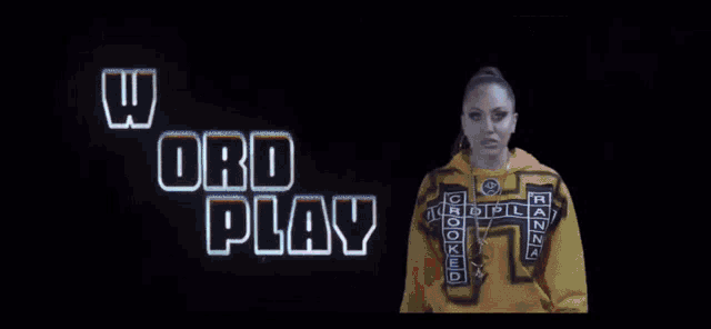 a woman in a yellow hoodie is standing in front of a cross in a video .