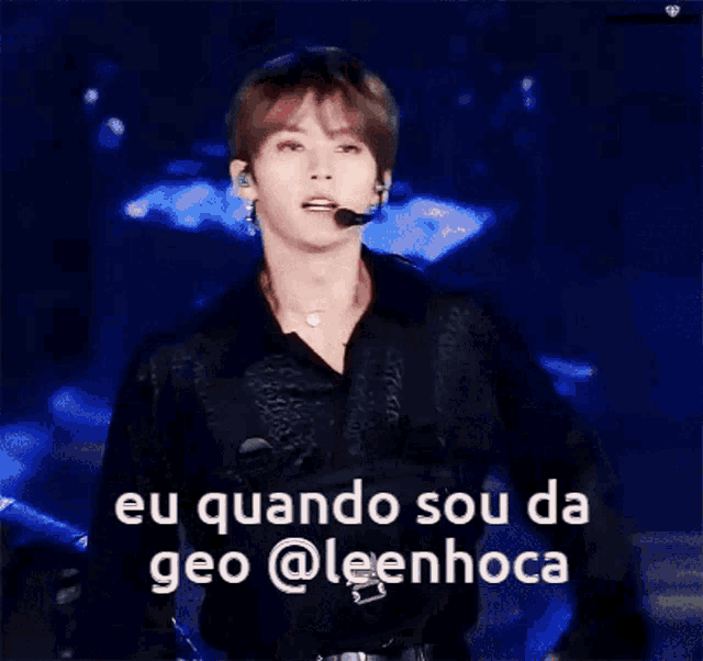 a man singing into a microphone with the words eu quando sou da geo @leenhoca written below him