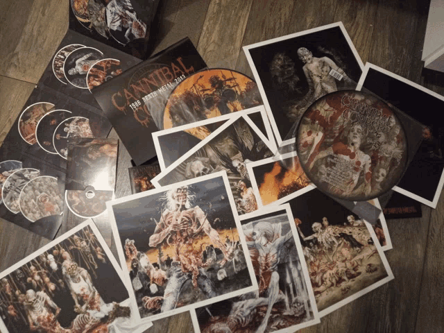 a stack of cannibal records and posters on a wooden floor