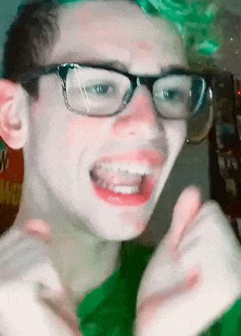 a young man wearing glasses and a green shirt