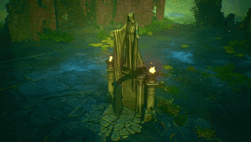 a statue of a man in a white robe is surrounded by two candles