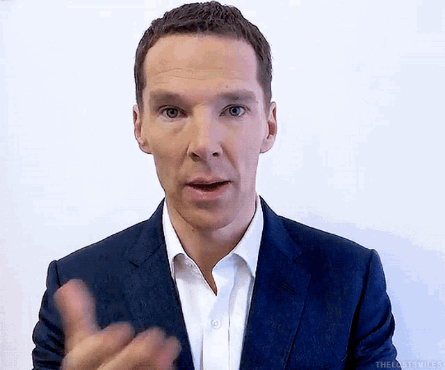 a man in a suit and white shirt is making a funny face