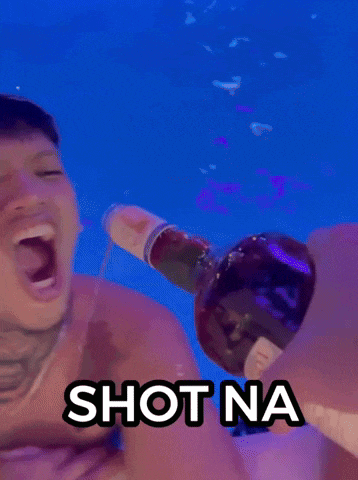 a man is drinking from a bottle with the words shot na written on the bottom