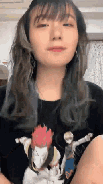 a close up of a woman wearing a black t-shirt with a picture of a man on it .