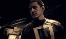 a man in a superhero costume is standing in the dark .