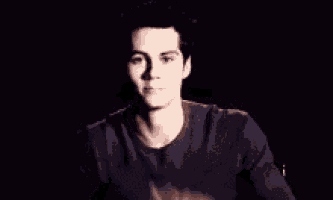 a man in a black shirt is making a funny face with his hands .