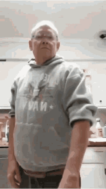 an elderly man wearing a gray hoodie with the word paw on it