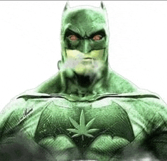 a green batman is smoking a cigarette while wearing a marijuana leaf on his chest .