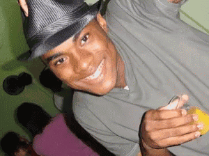 a man wearing a hat and a grey shirt is smiling