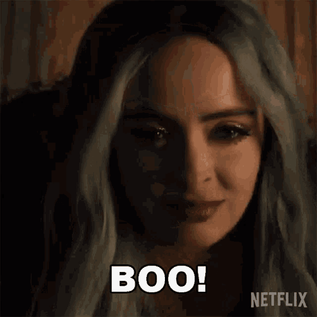 a close up of a woman 's face with the words `` boo '' written on her face .