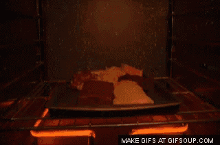 a gif of a man taking a tray of food out of an oven