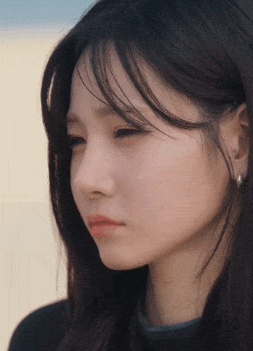 a close up of a woman 's face with earrings on