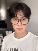 a man wearing glasses and a white shirt is looking at the camera .